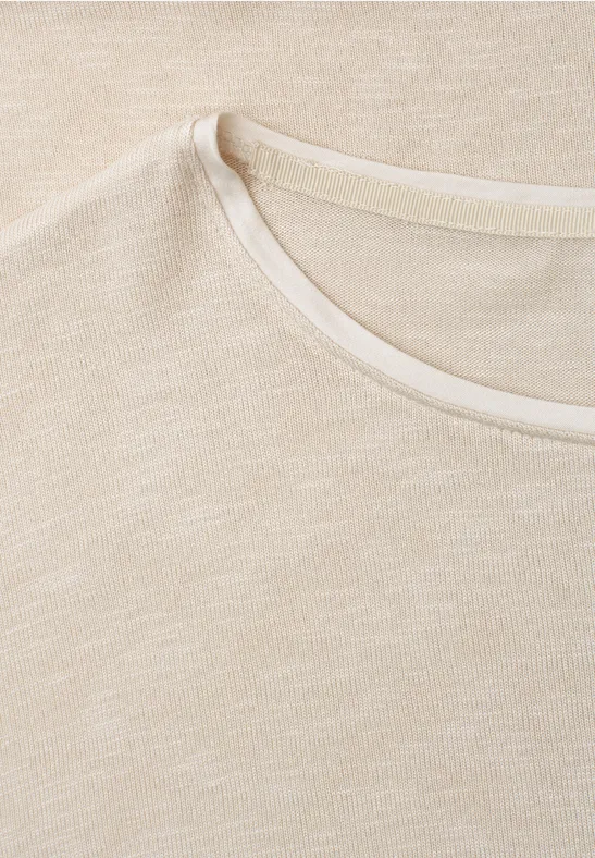 Close-up van een lichtbeige katoenen T-shirt met ronde hals.