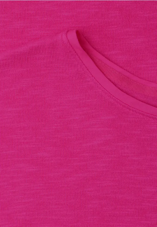 Nahaufnahme eines pinkfarbenen T-Shirts mit Rundhalsausschnitt und fein melierter Struktur