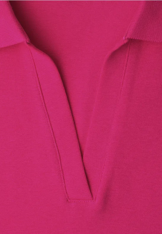 Close-up van een felroze poloshirt met V-hals