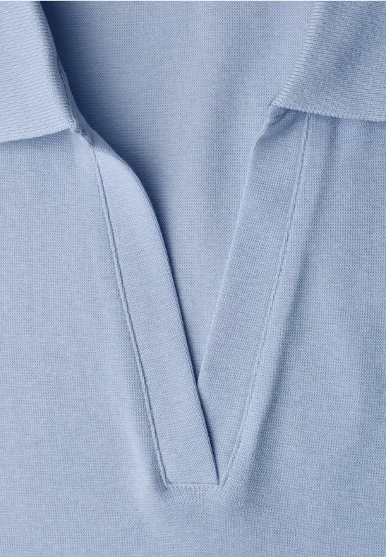 Close-up van een lichtblauw poloshirt met V-hals.