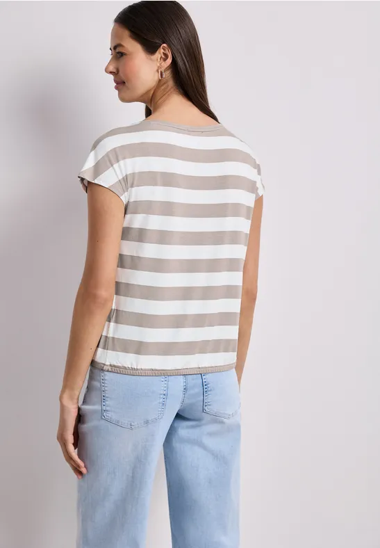 Frau von hinten mit gestreiftem T-Shirt und hellblauen Jeans.