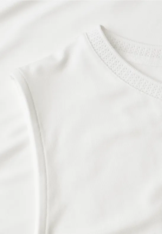 Nahaufnahme eines weißen, ärmellosen Baumwoll-T-Shirts mit feiner Struktur.