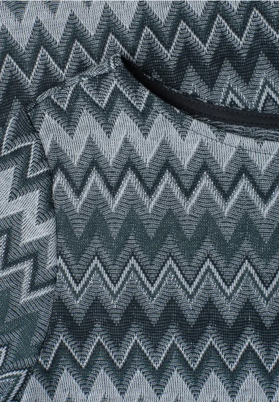 Close-up van een grijze zigzagstof met zwarte zakopening.