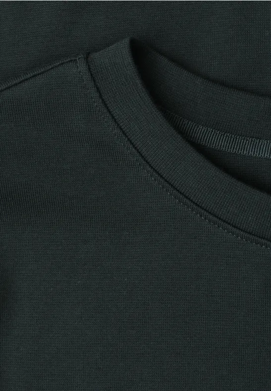 Close-up van de hals en het stiksel van een zwart T-shirt.