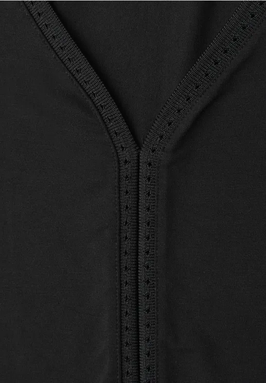 Schwarzer Stoff mit dekorativer Lochnaht in V-Form.