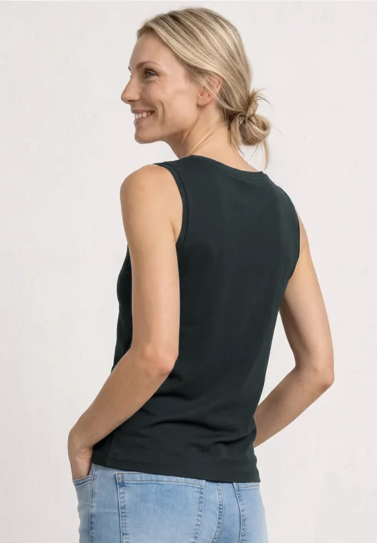 Achteraanzicht van een vrouw in een zwart mouwloos hemd en spijkerbroek, haren in een losse knot.