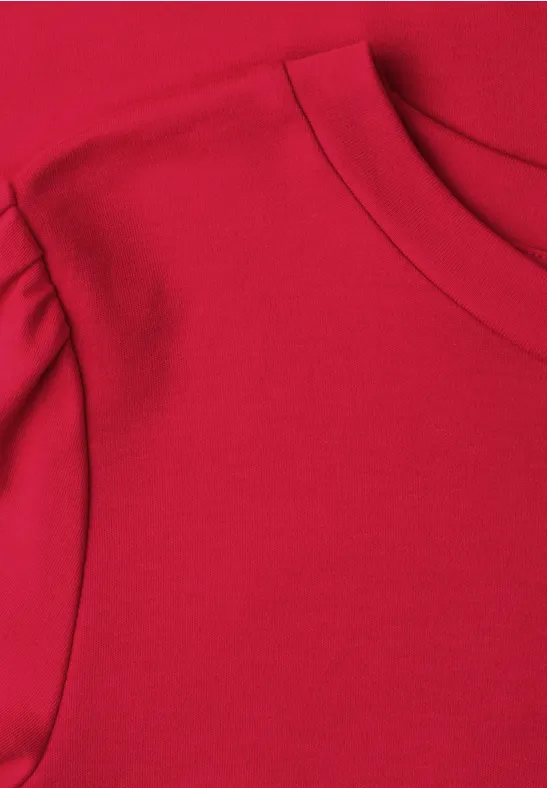 Nahaufnahme eines roten T-Shirts mit Rundhalsausschnitt und überschnittener Schulter