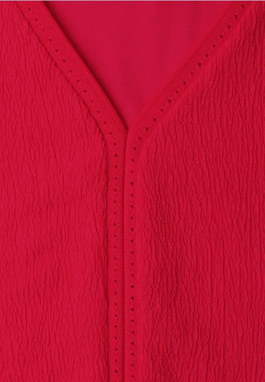 Rote, strukturierte V-Ausschnitt-Bluse aus leichtem Stoff.