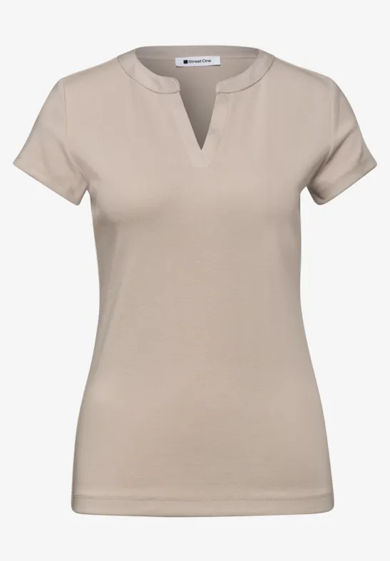 Beige damesshirt met korte mouwen en V-halsinsnijding.
