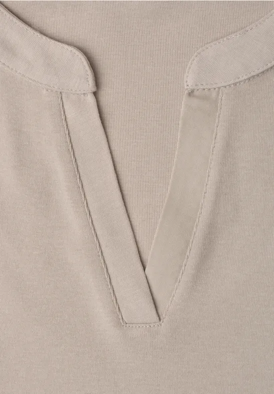 Beige top met V-hals en decoratieve stiknaden