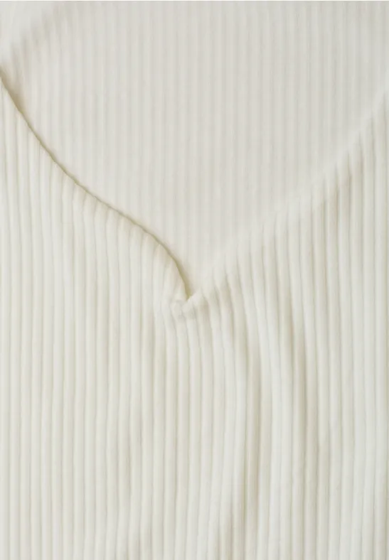 Nahaufnahme eines cremefarbenen, gerippten V-Ausschnitt-Oberteils.