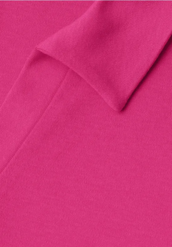 Een felroze stof met fijne structuur en subtiele plooien.