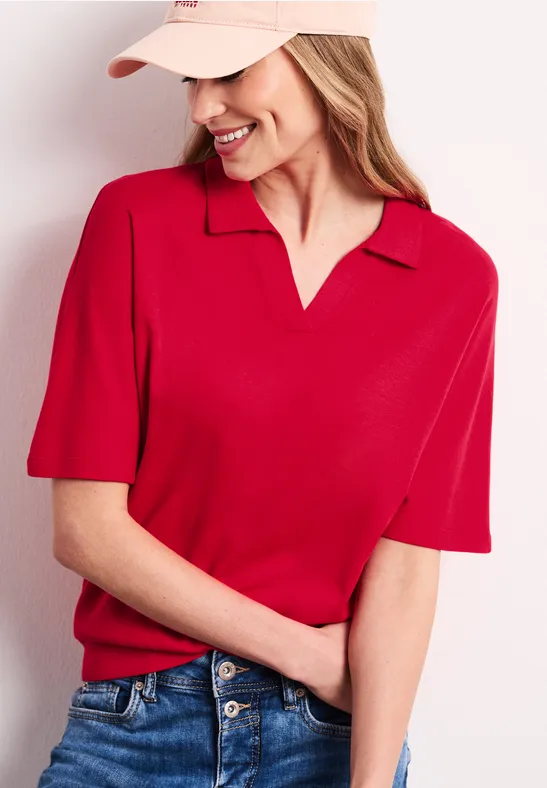 Persoon in rood T-shirt met korte mouwen, col en V-hals, pet, lichte achtergrond