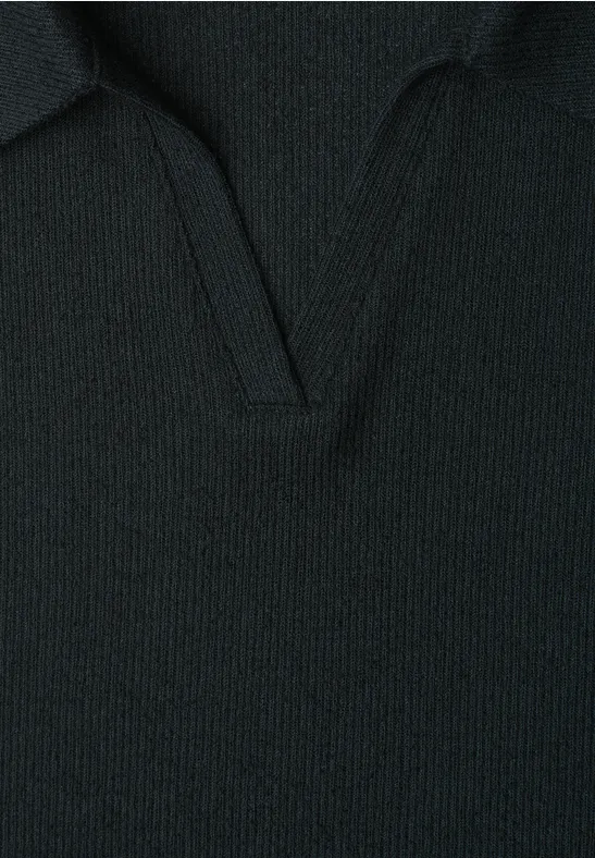 Close-up van een zwarte, grofgebreide trui met V-halskraag.