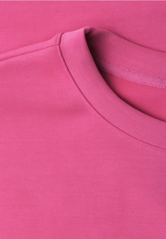 Nahe Aufnahme eines pinken T-Shirts mit Rundhalsausschnitt.