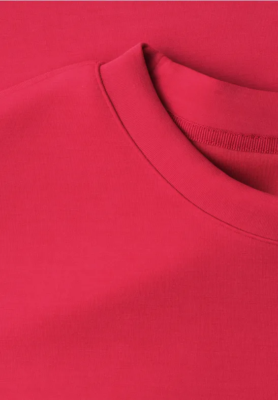 Ein rotes T-Shirt mit Rundhalsausschnitt, nur Kragen und oberer Bereich sichtbar.