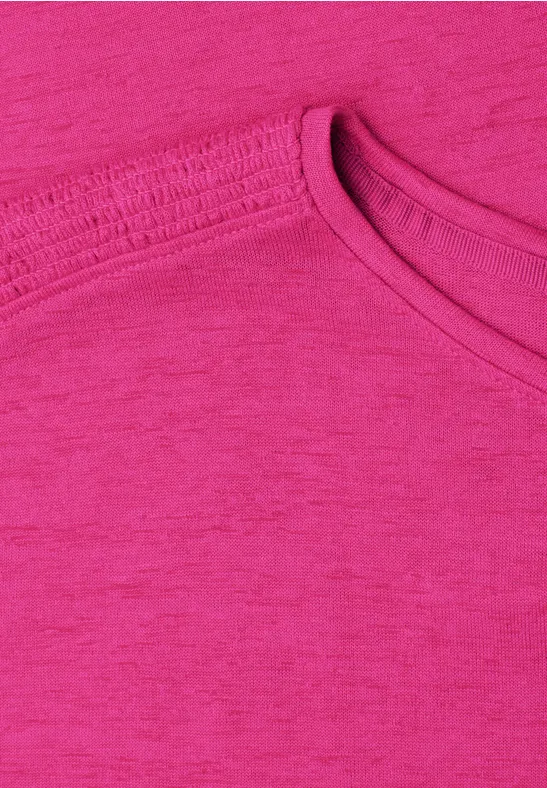 Nahaufnahme eines pinkfarbenen T-Shirts mit Rundhalsausschnitt.