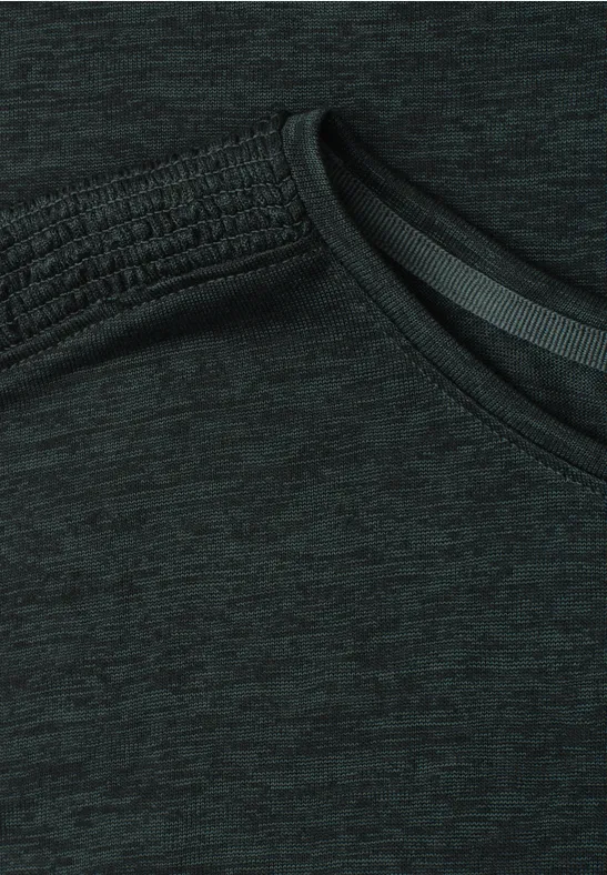 Nahaufnahme eines dunklen Sportshirts mit schrägem Ausschnitt und meliertem Stoff.