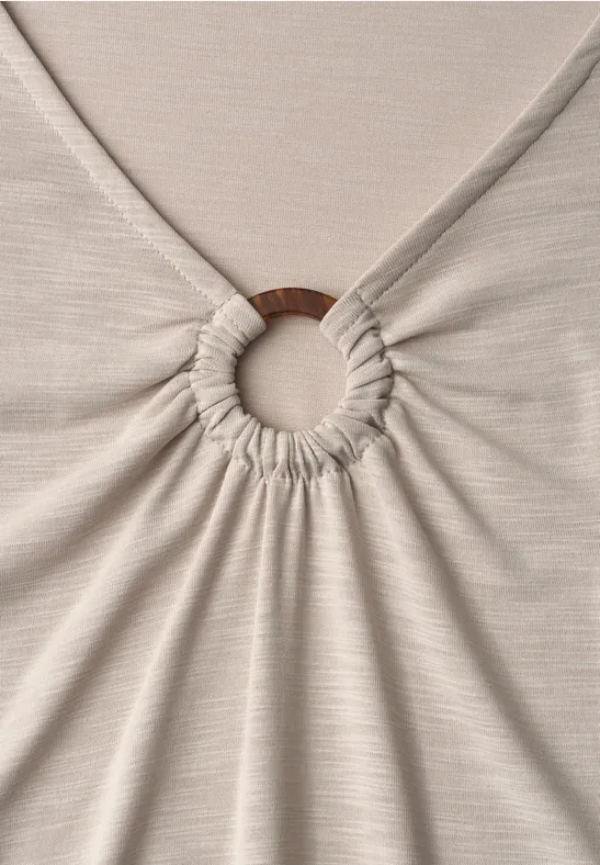 Beige stof samengebracht in het midden door een houten ring.