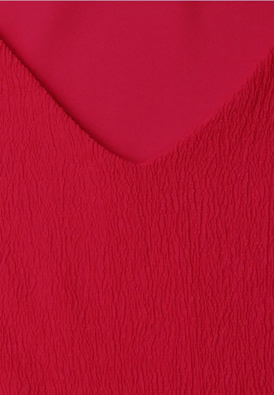 Close-up van rood, gestructureerd textiel met V-vormig patroon