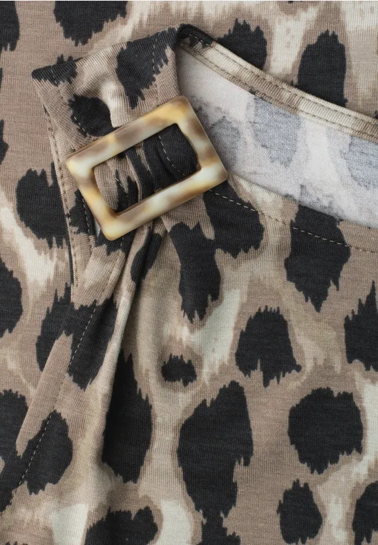 Close-up van een riem met gouden gesp en luipaardprint op stof.