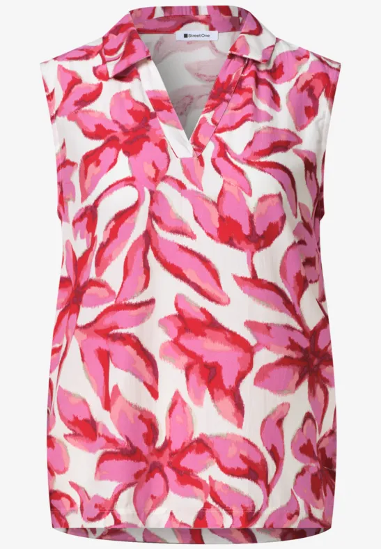 Mouwloze top met V-hals, witte basis met felroze bloemmotief.