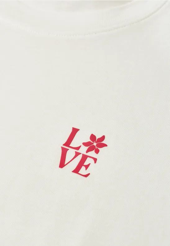 Weißes T-Shirt mit rotem LOVE-Schriftzug, bei dem das O als Blütenmotiv gestaltet ist.