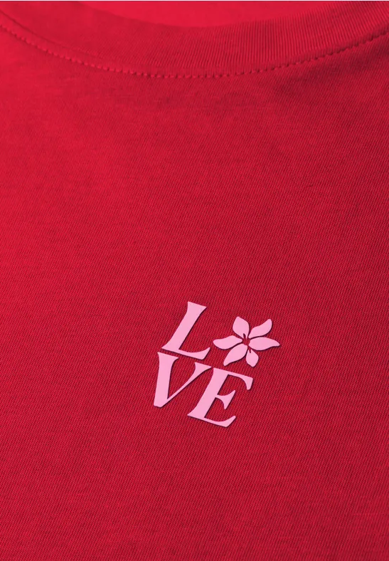 Rood T-shirt met witte LOVE-opdruk, waarbij de O is vervangen door een gestileerde bloem.