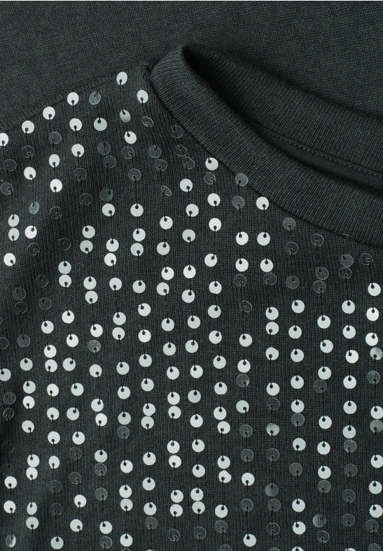 Gros plan d'un tissu noir orné de paillettes argentées brillantes