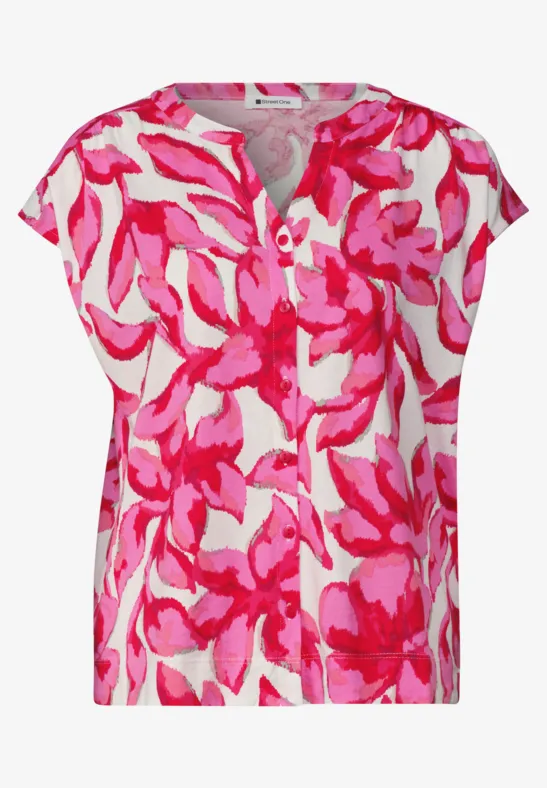 Kurze Damenbluse mit pink-rosa Blumenmuster auf weißem Grund und Rundhalsausschnitt.