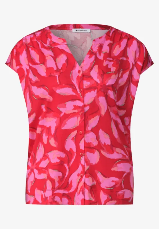 Rote Damenbluse mit pinken, abstrakten Blumenmustern und V-Ausschnitt, kurzärmelig, sommerlich.