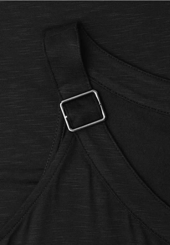 Close-up van zwarte stof met verstelbare band en zilverkleurige metalen gesp.