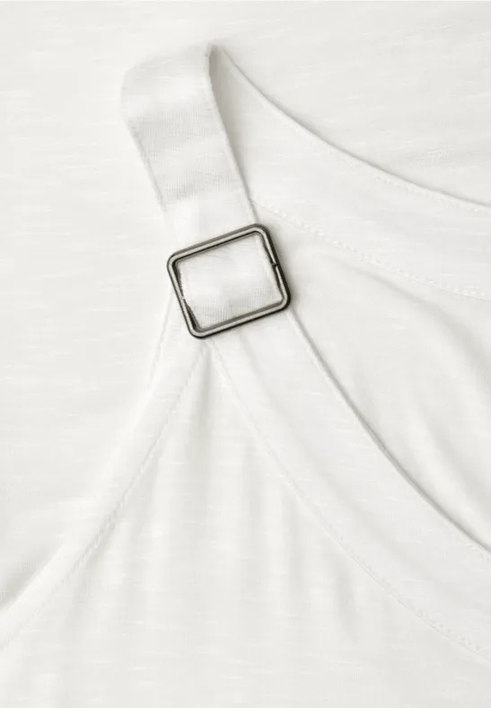 Close-up van een witte band met vierkante metalen verstelgesp aan een kledingstuk