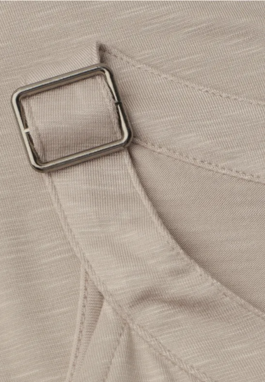 Nahaufnahme eines beigen Stoffbands mit quadratischer Metallschnalle