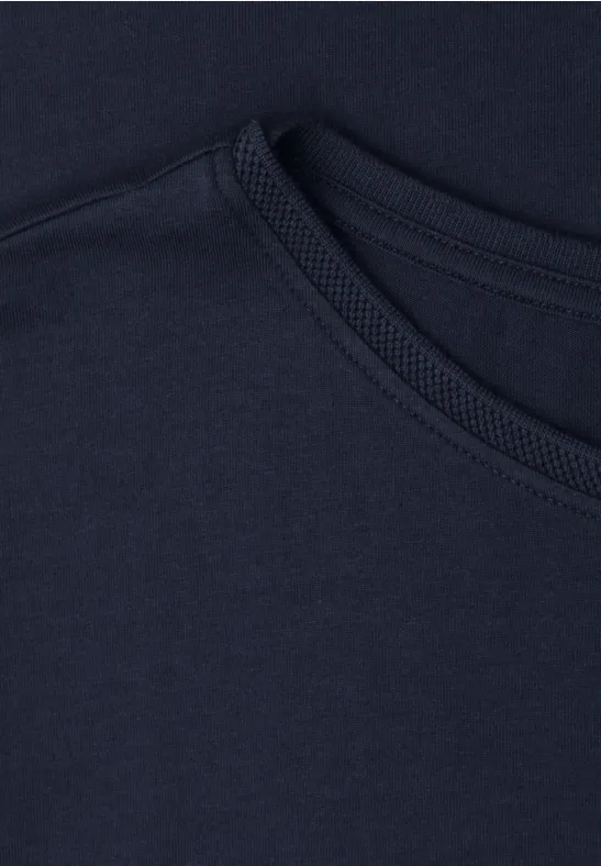 Close-up van twee overlappende donkerblauwe T-shirtkragen van katoenen stof.