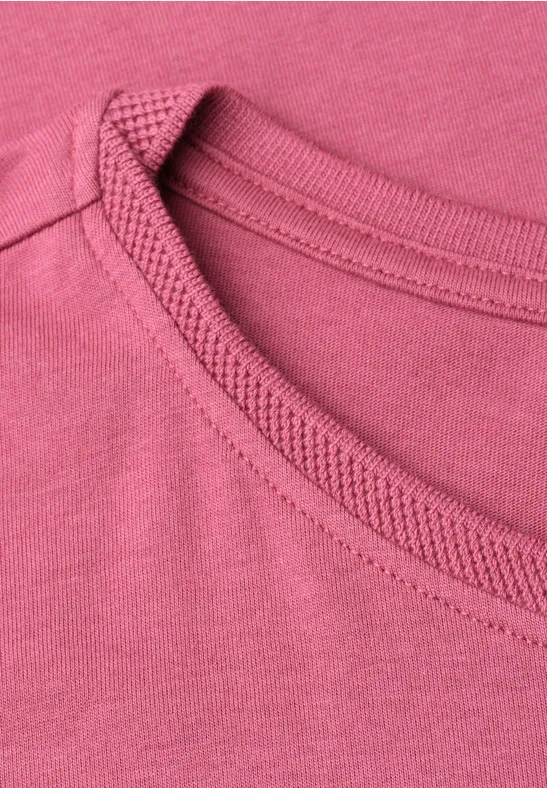 zbliżenie na różowy dekolt w okrągłym T-shircie.