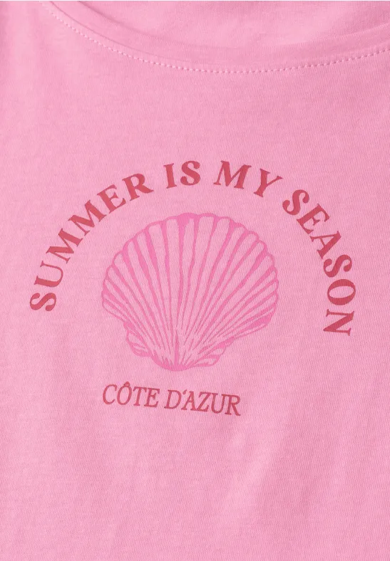 Roze shirt met schelp-illustratie en tekst 'SUMMER IS MY SEASON' en 'CÔTE D'AZUR'.