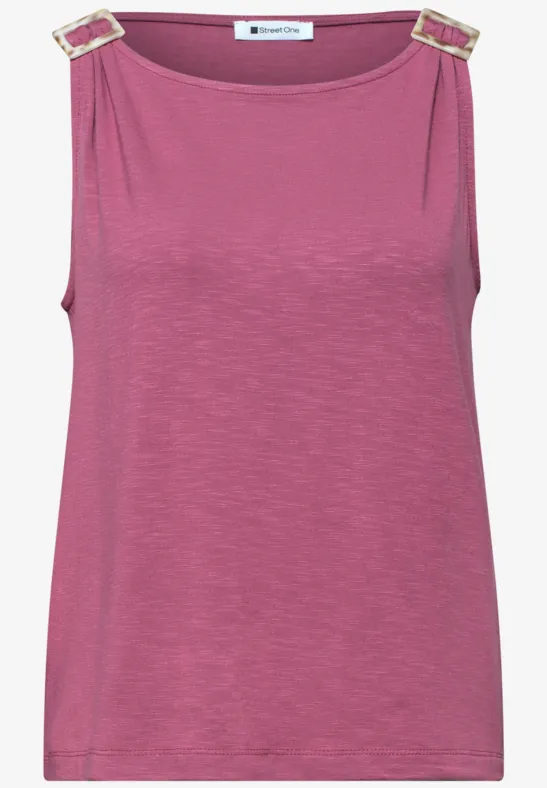 Fuchsia mouwloos top met gouden gespen op de schouders.