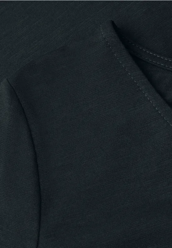 Zwarte stofstructuur met naad en zakopening van een kledingstuk