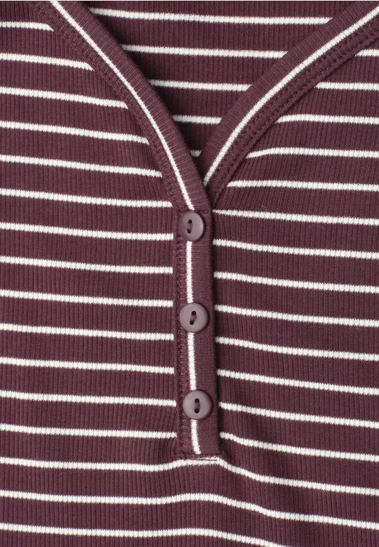 Nahaufnahme eines lila-weiß gestreiften Shirts mit Knopfleiste und drei Knöpfen.