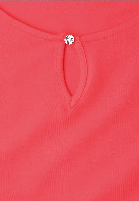 Rotes Oberteil mit kleinem Tropfenausschnitt und rundem Zierknopf