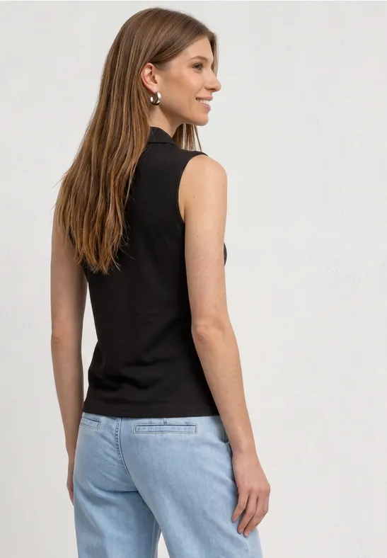 Eine Frau von hinten in ärmellosem schwarzem Oberteil und hellblauen Jeans.