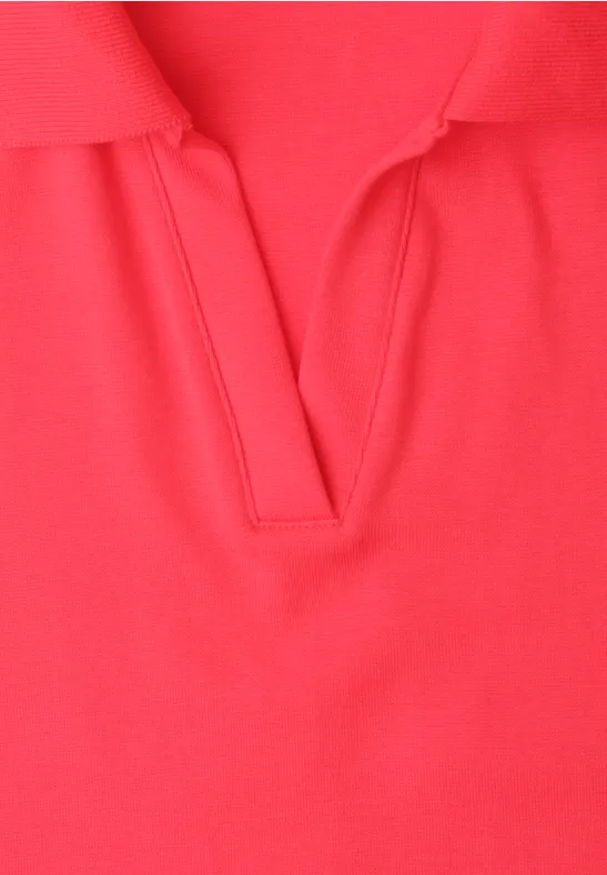 Gros plan d’un polo rouge avec encolure en V.