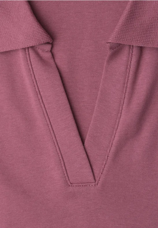 Gros plan sur un haut en maille lilas à encolure en V.