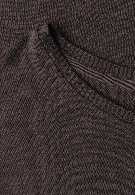 Gros plan sur un pull en maille brun foncé avec col rond