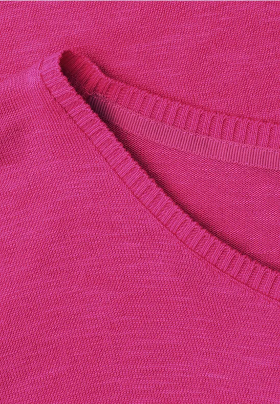 Close-up van een fuchsia gebreid stof met fijne steken en een afgeronde halslijn
