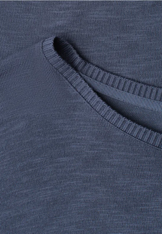 Nahaufnahme eines dunkelblauen Rundhalsausschnitts mit feinem Strickmuster.