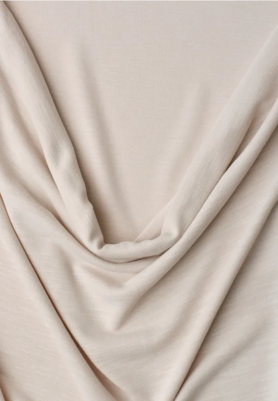 Beige, weicher Stoff mit eleganten Falten drapiert.