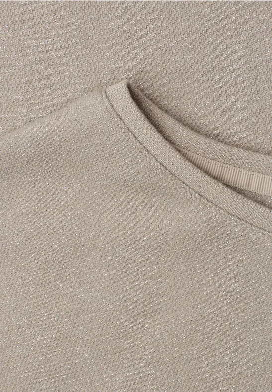 Close-up van de beige halslijn van een T-shirt in zachte, gestructureerde stof.