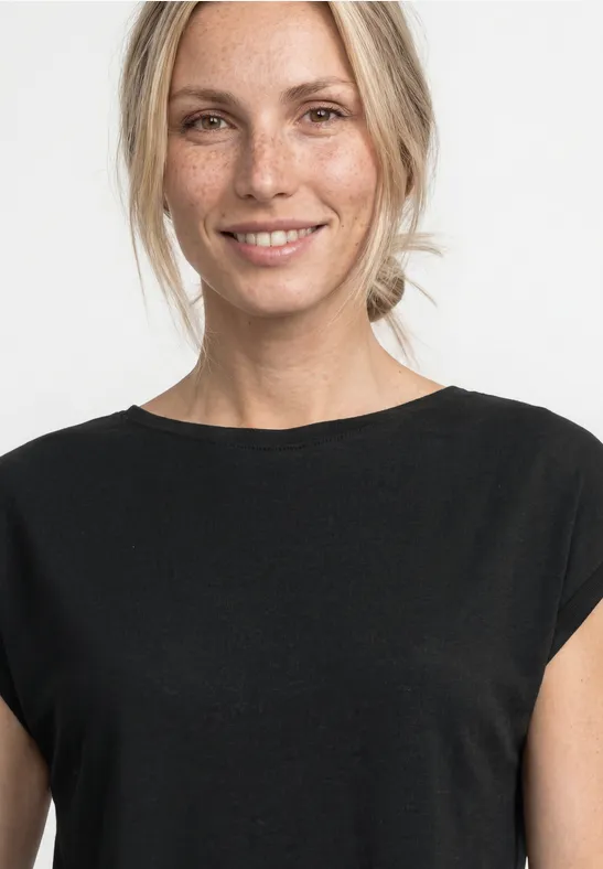 Eine Person mit verpixeltem Gesicht trägt ein schwarzes Shirt vor hellem Hintergrund.